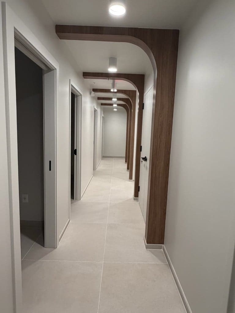 Modern corridor with wood ceiling arches and tile flooring